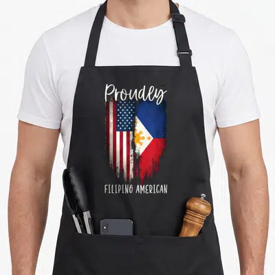 Vintage filipino american flag apron - Distressed composite of two flags with Proudly and FILIPINO AMERICAN text — shown on a black cotton canvas apron against a white background