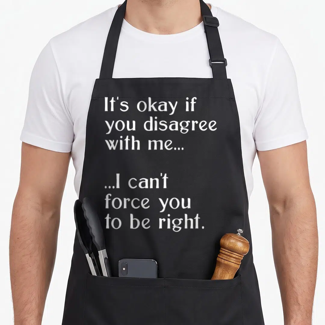 Force best debate ever apron - White text reading It's okay if you disagree with me I can't force you to be right — shown on a black cotton canvas apron against a white background