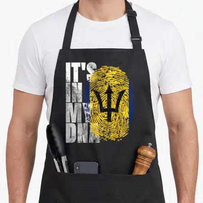 Trident barbadian apron - IT'S IN MY DNA text next to yellow blue fingerprint with black trident in distressed style — shown on a black cotton canvas apron against a white background