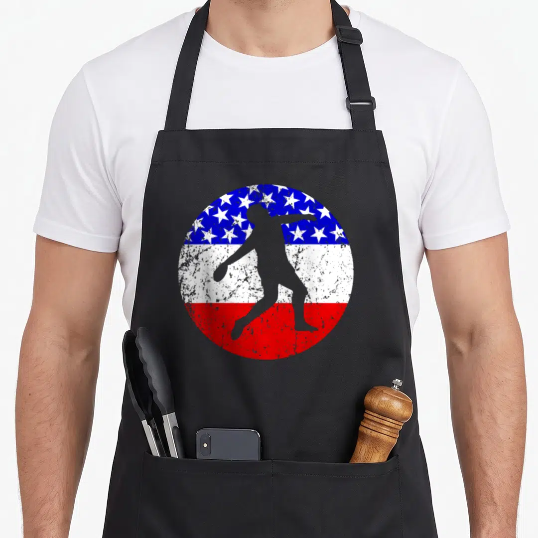 Discus american flag apron - Grey discus thrower silhouette over distressed blue star and red white stripe circle — shown on a black cotton canvas apron against a white background
