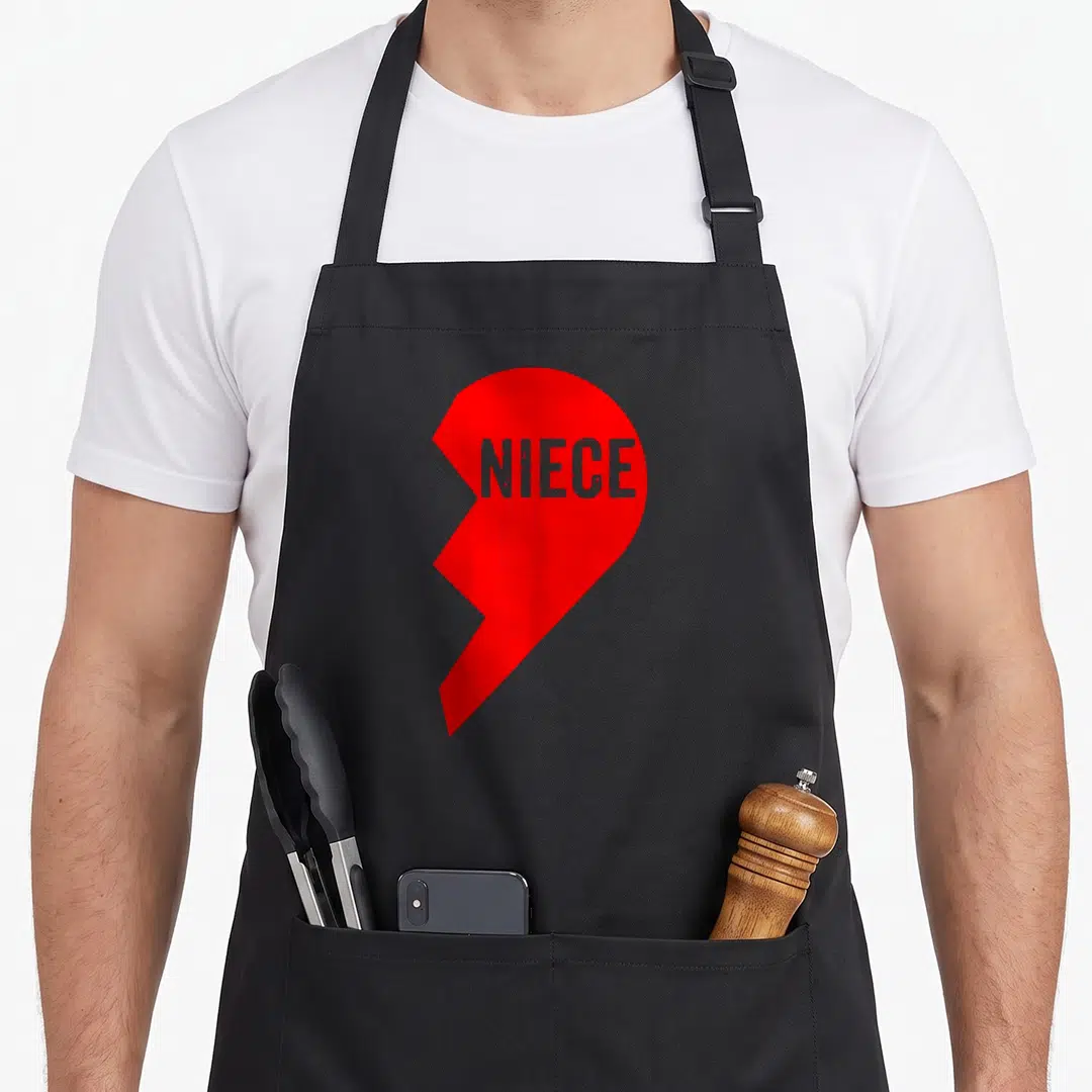 Aunt outfit niece apron - Red heart with jagged left edge containing grey distressed NIECE text — shown on a black cotton canvas apron against a white background
