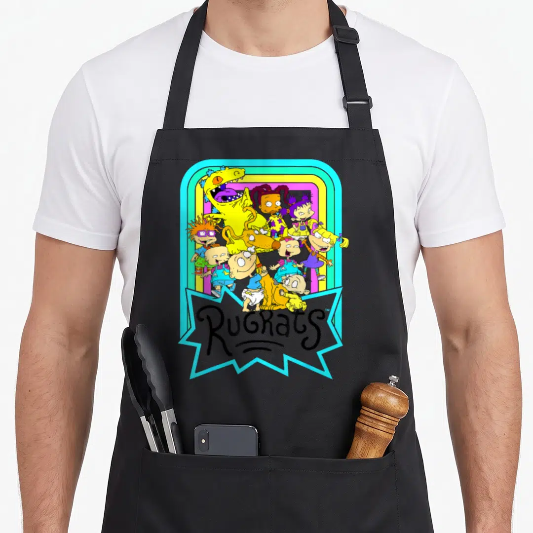 Neon rainbow apron - Rugrats characters in rainbow frame with blue jagged logo bubble — shown on a black cotton canvas apron against a white background