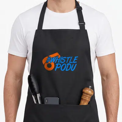 Whistle cricket apron - Blue #WHISTLE PODU text over orange abstract shape — shown on a black cotton canvas apron against a white background