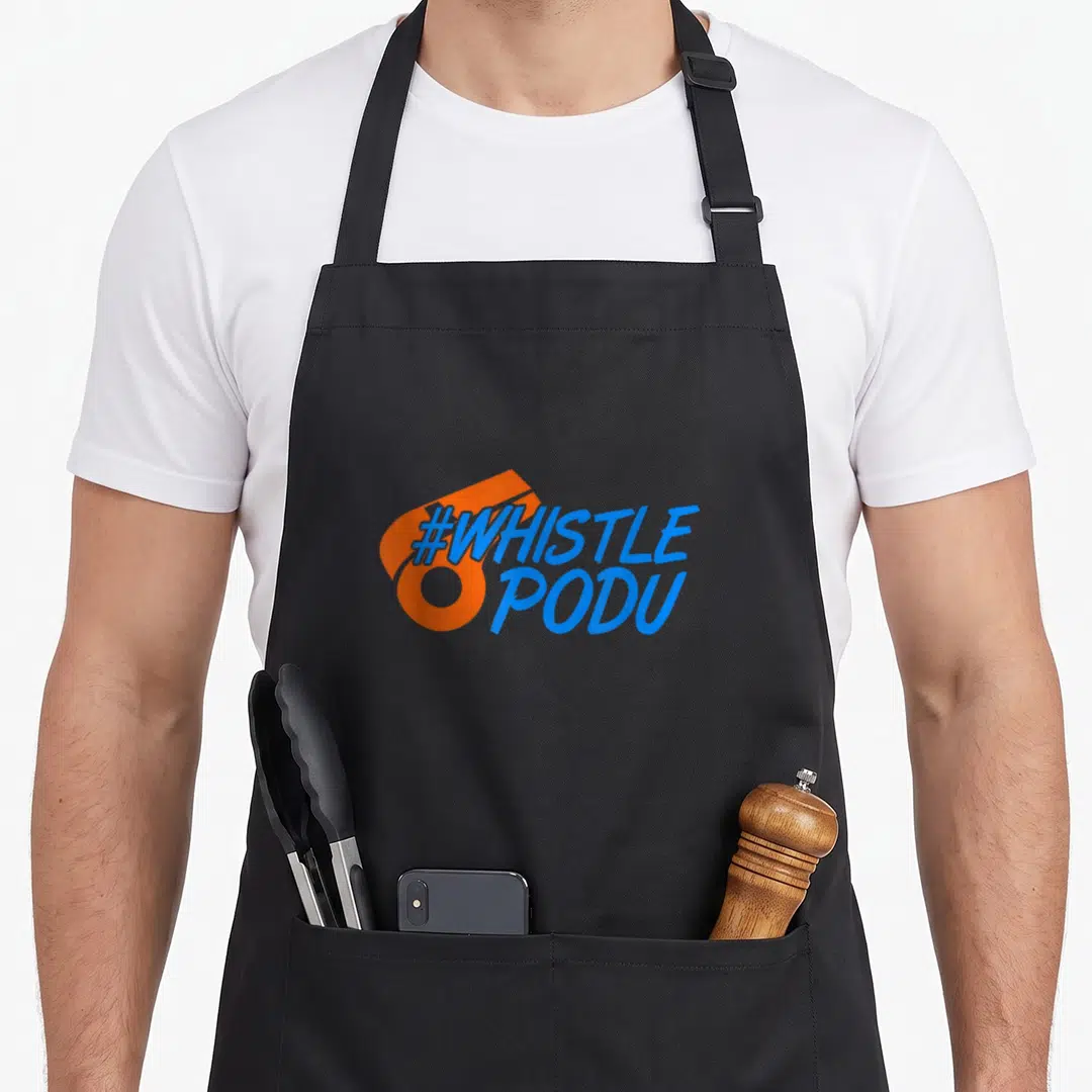 Whistle cricket apron - Blue #WHISTLE PODU text over orange abstract shape — shown on a black cotton canvas apron against a white background