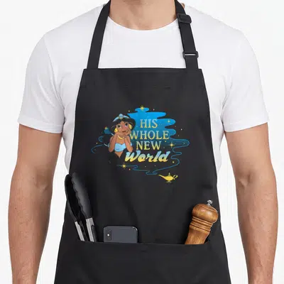His jasmine apron - Cartoon woman next to His Whole New World text and magic lamp on black apron — shown on a black cotton canvas apron against a white background