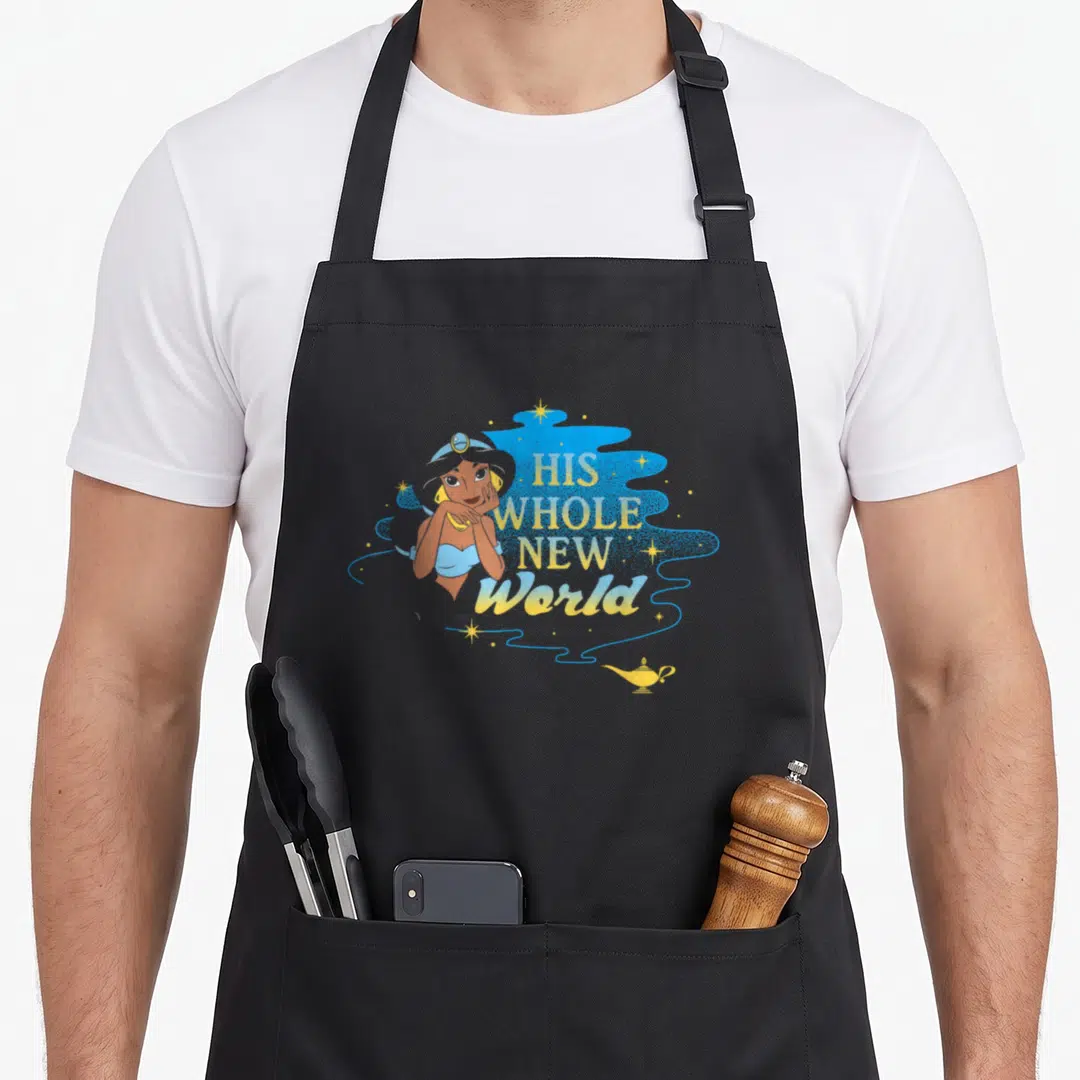 His jasmine apron - Cartoon woman next to His Whole New World text and magic lamp on black apron — shown on a black cotton canvas apron against a white background