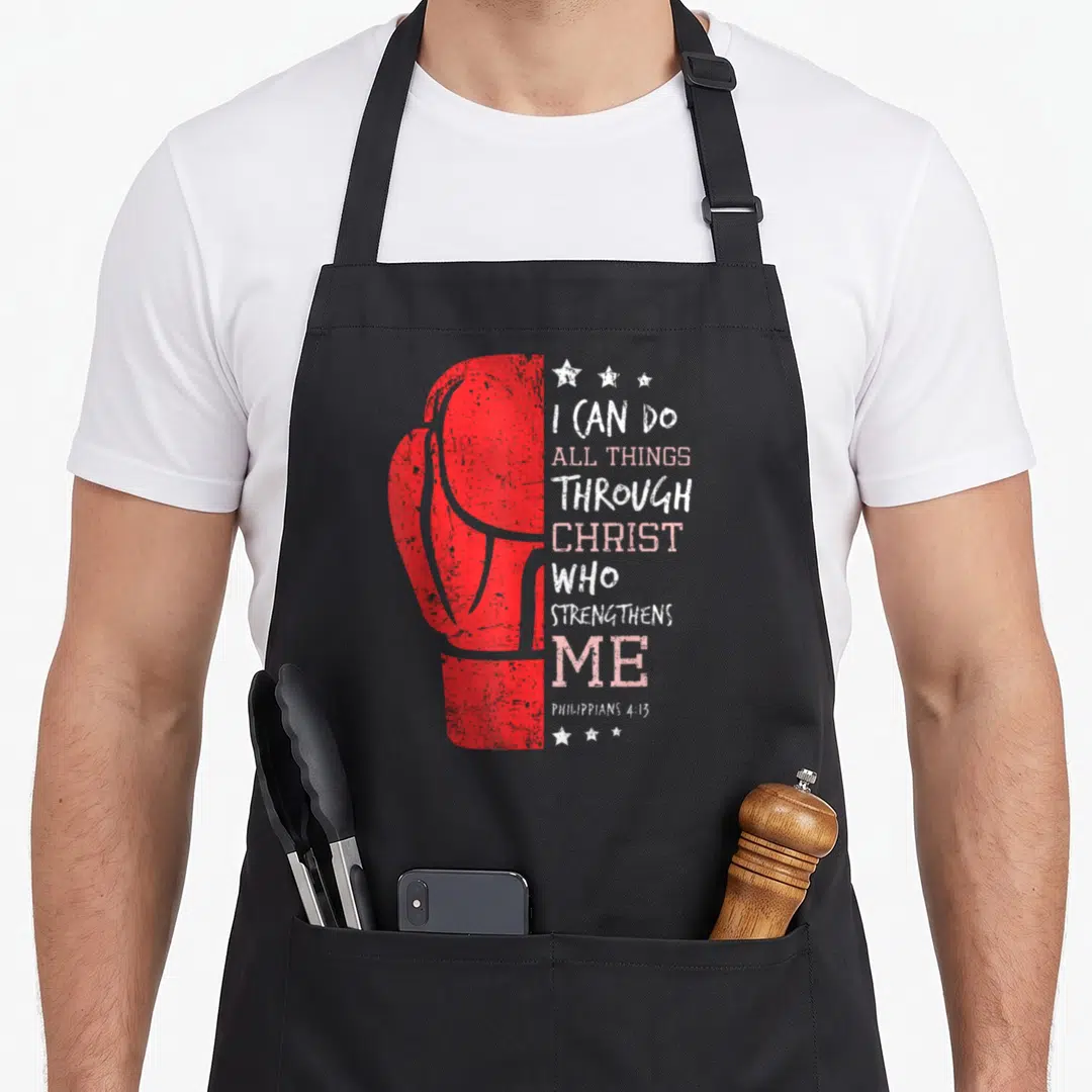 Boxing christian apron - Red distressed boxing glove next to stacked white and pink Philippians 4:13 lettering — shown on a black cotton canvas apron against a white background