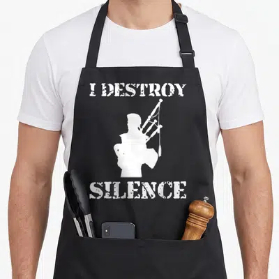 Destroy bagpipes apron - White bagpiper silhouette flanked by I DESTROY SILENCE text — shown on a black cotton canvas apron against a white background
