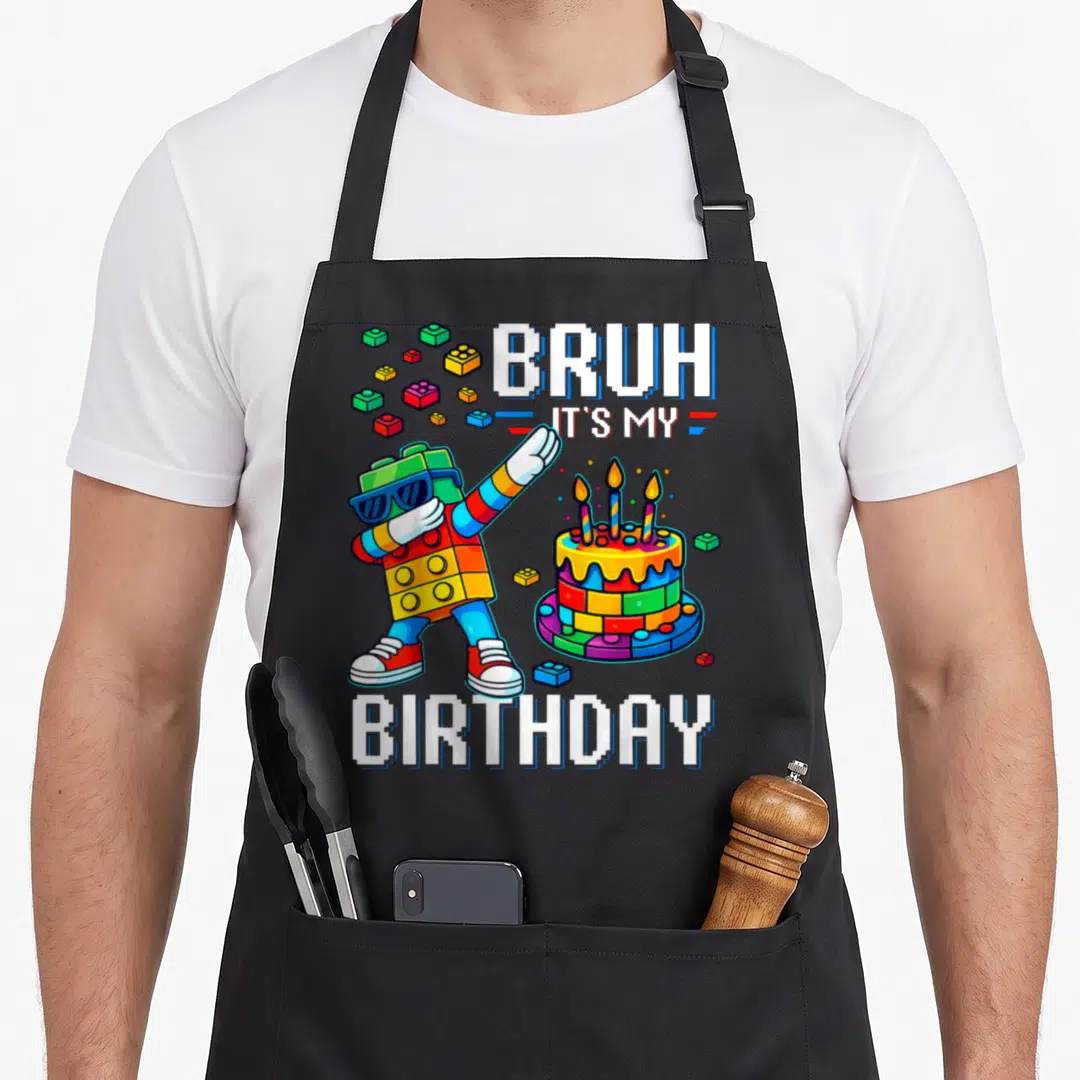 Bruh grill master apron - Pixel art block figure dabbing next to birthday cake and scattered bricks with text — shown on a black cotton canvas apron against a white background