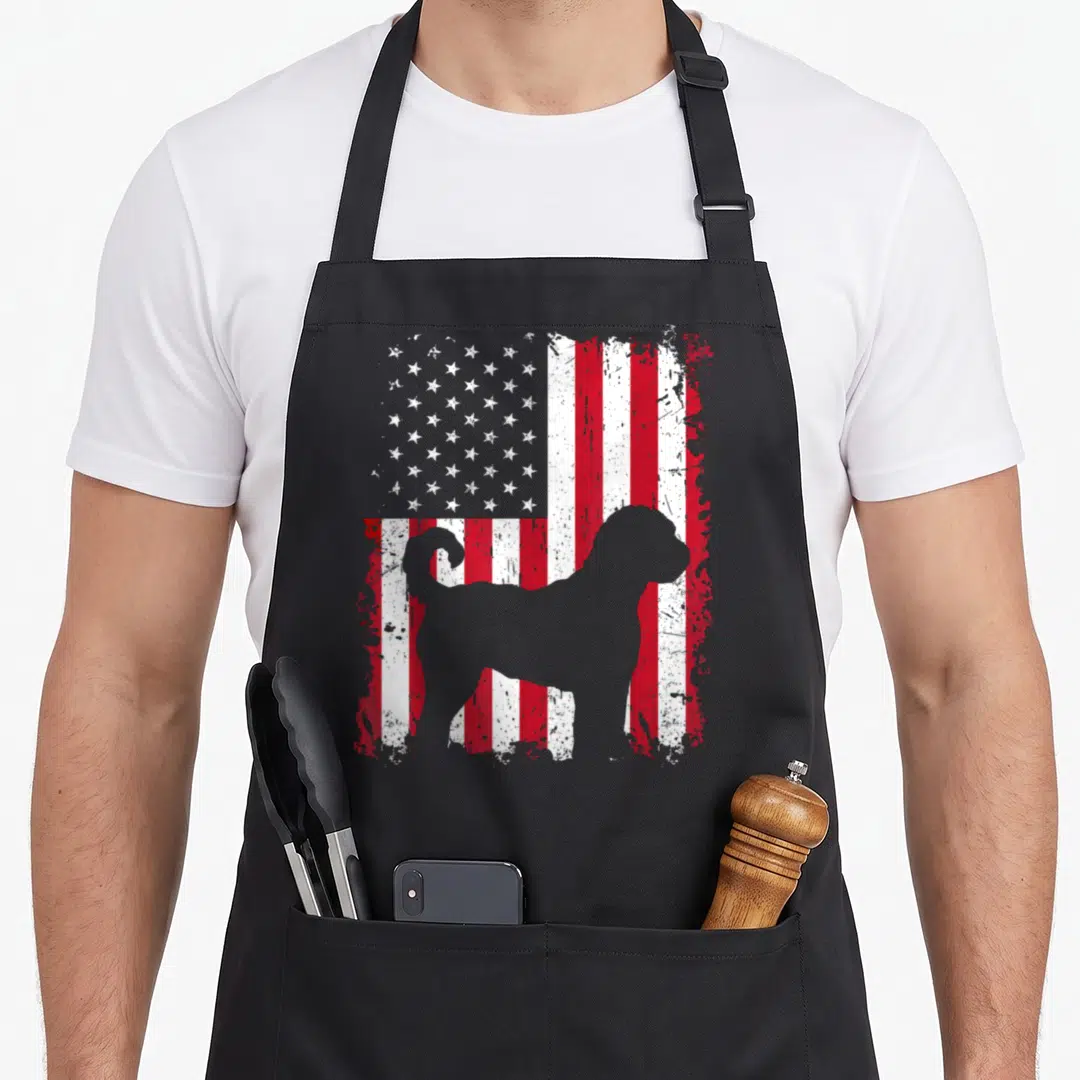 Labradoodle 4th of july apron - Grey dog silhouette standing in front of a distressed red white and grey American flag — shown on a black cotton canvas apron against a white background