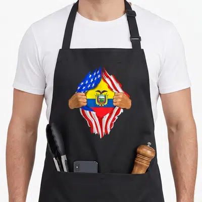 Ecuadorian blood apron - Two hands tearing USA flag to reveal Ecuador flag with yellow blue red and white stripes — shown on a black cotton canvas apron against a white background