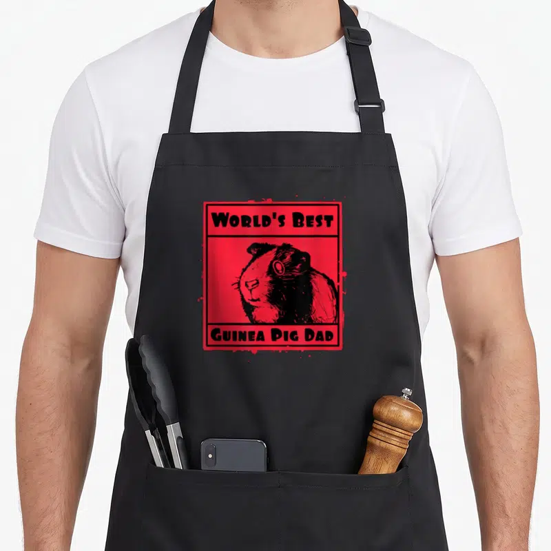 Vintage pig guinea dad apron - Red frame with black guinea pig illustration and text reading World's Best Guinea Pig Dad — shown on a black cotton canvas apron against a white background