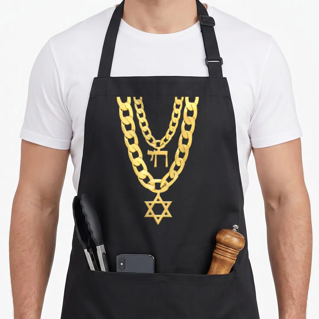 Chai hanukkah apron - Realistic gold necklace with two chains, Hebrew Chai text, and Star of David pendant — shown on a black cotton canvas apron against a white background