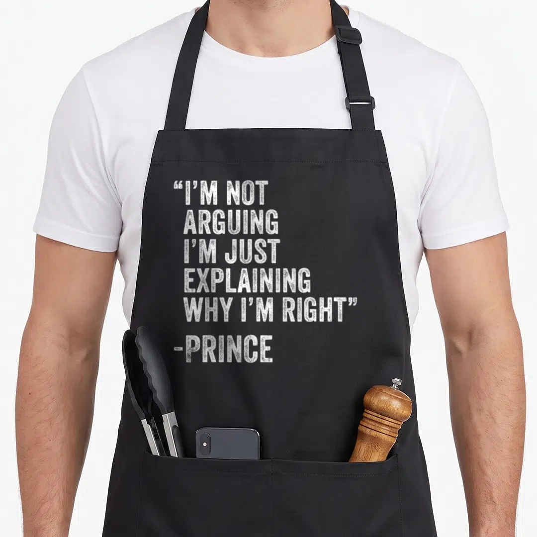 Engineer birthday apron - White stacked text reading I'm not arguing I'm just explaining why I'm right Prince — shown on a black cotton canvas apron against a white background