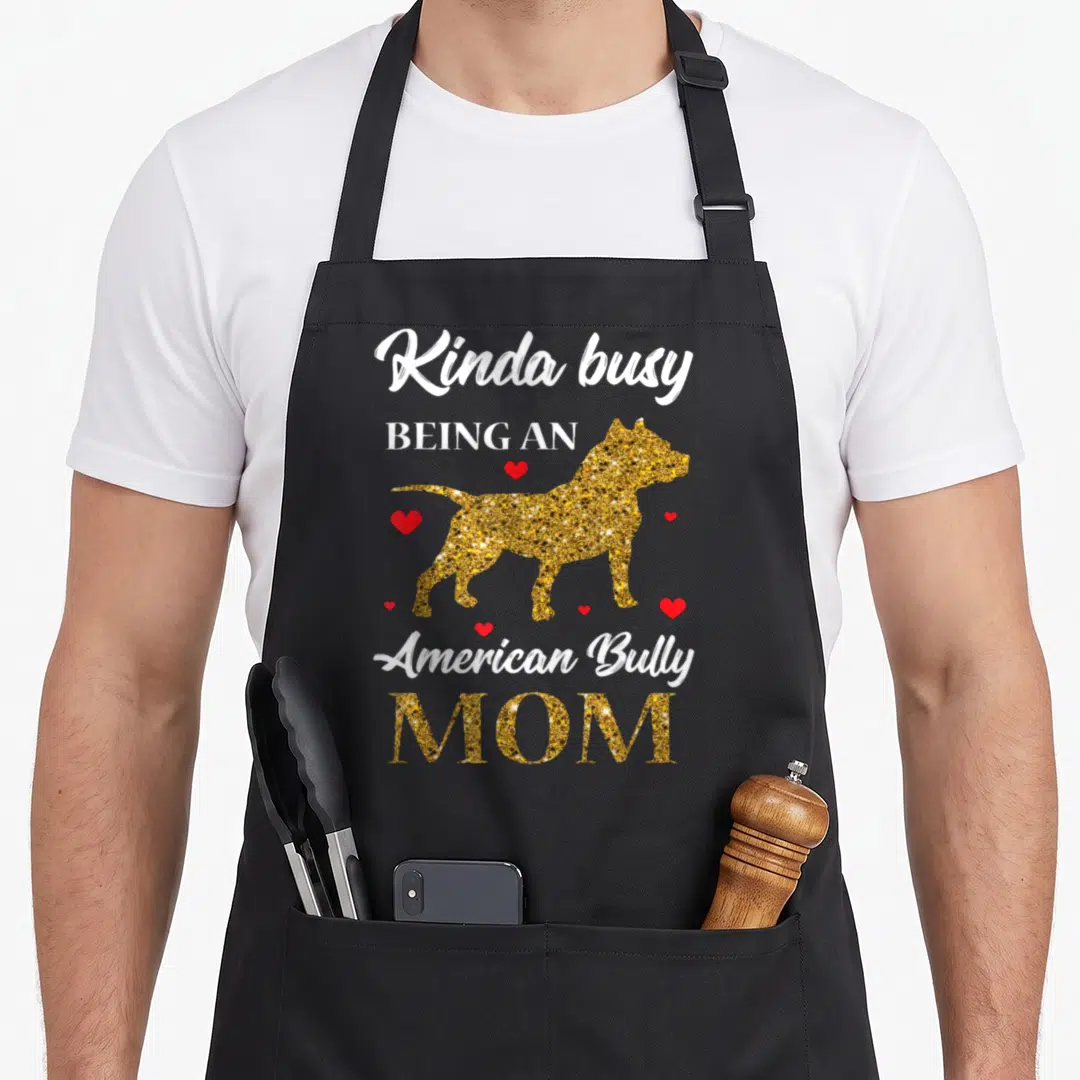 Pitty mama apron - Gold glitter American Bully dog silhouette surrounded by red hearts and white stacked text — shown on a black cotton canvas apron against a white background
