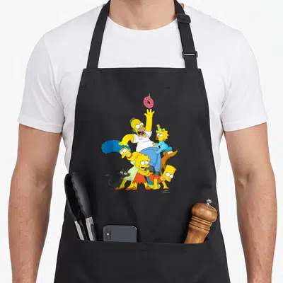 Donut family aprons - Simpson family cluster reaching for pink donut cartoon art — shown on a black cotton canvas apron against a white background