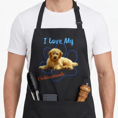 Paw goldendoodle apron - I Love My Goldendoodle text above and below a golden dog photo inside a blue paw print outline — shown on a black cotton canvas apron against a white background