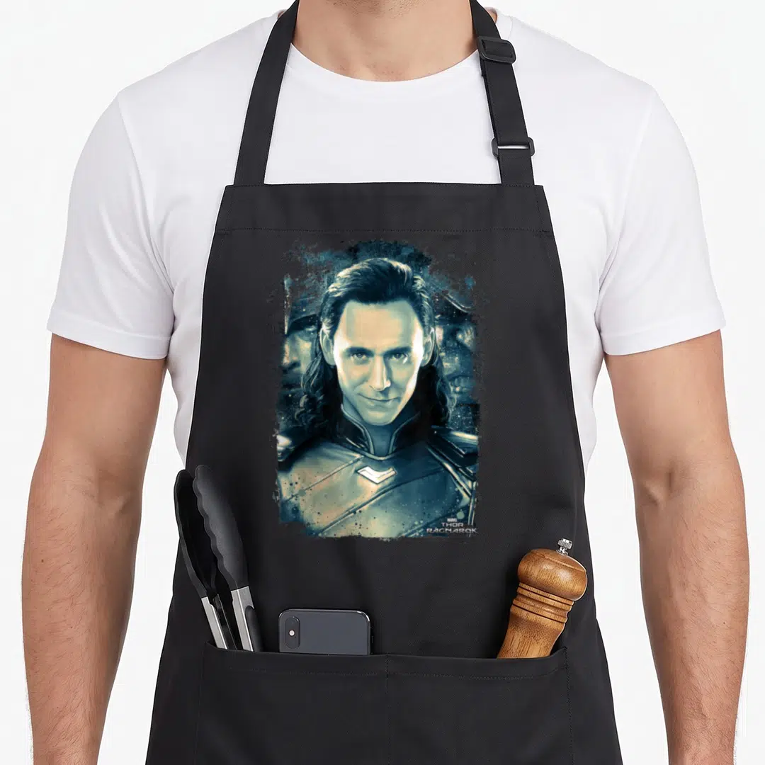 Ragnarok distressed apron - Loki portrait in teal white black with Marvel Thor Ragnarok text — shown on a black cotton canvas apron against a white background