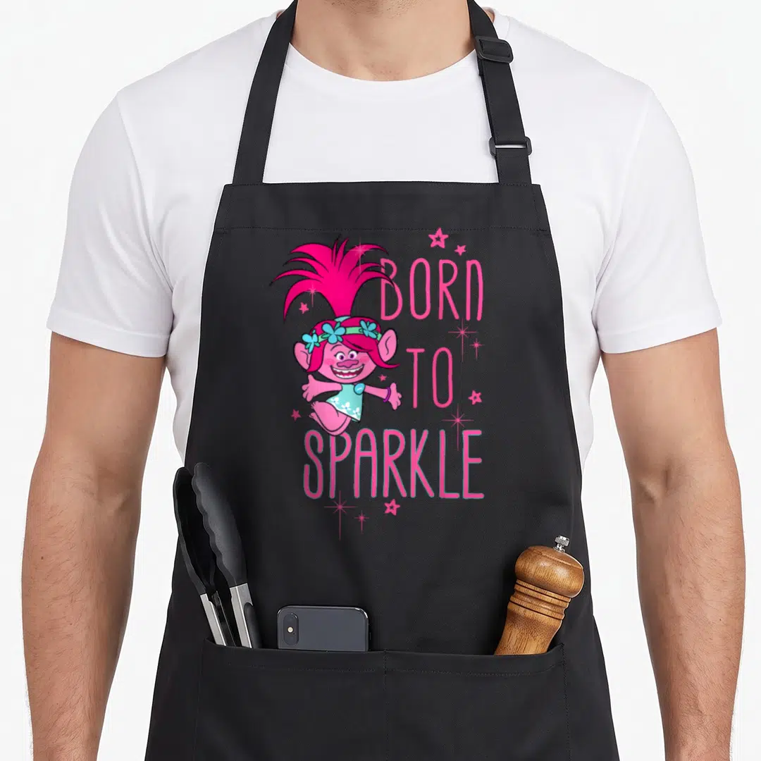 Sparkle troll apron - Pink troll character with BORN TO SPARKLE text and teal accents surrounded by stars — shown on a black cotton canvas apron against a white background