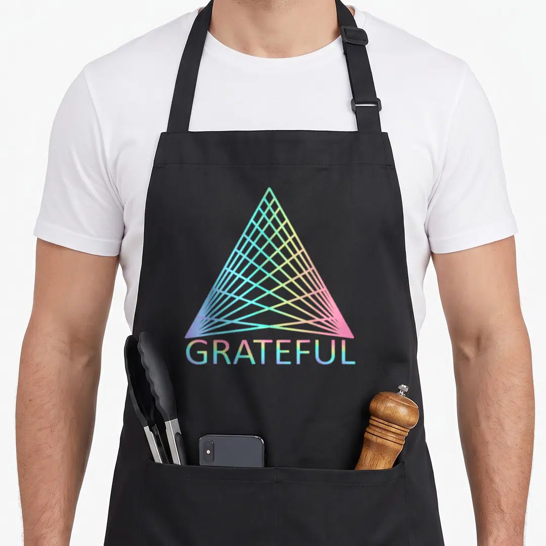 Spiritual trinity apron - Gradient triangle with blue pink and yellow lines above GRATEFUL text — shown on a black cotton canvas apron against a white background