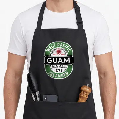Hafa guam aprons - Retro oval Guam emblem with Hafa Adai 671 text in green white black and red — shown on a black cotton canvas apron against a white background