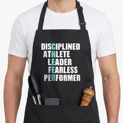 Cheerleader cheer apron - Stacked white text with teal CHEER acronym spelling out Disciplined Athlete Leader Fearless — shown on a black cotton canvas apron against a white background