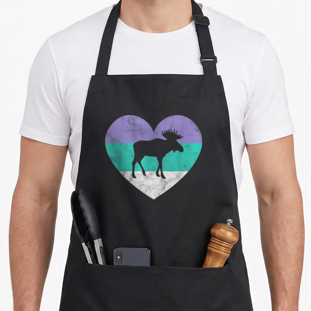 Moose apron for women - Grey moose silhouette inside a heart with purple, teal, and white horizontal bands — shown on a black cotton canvas apron against a white background