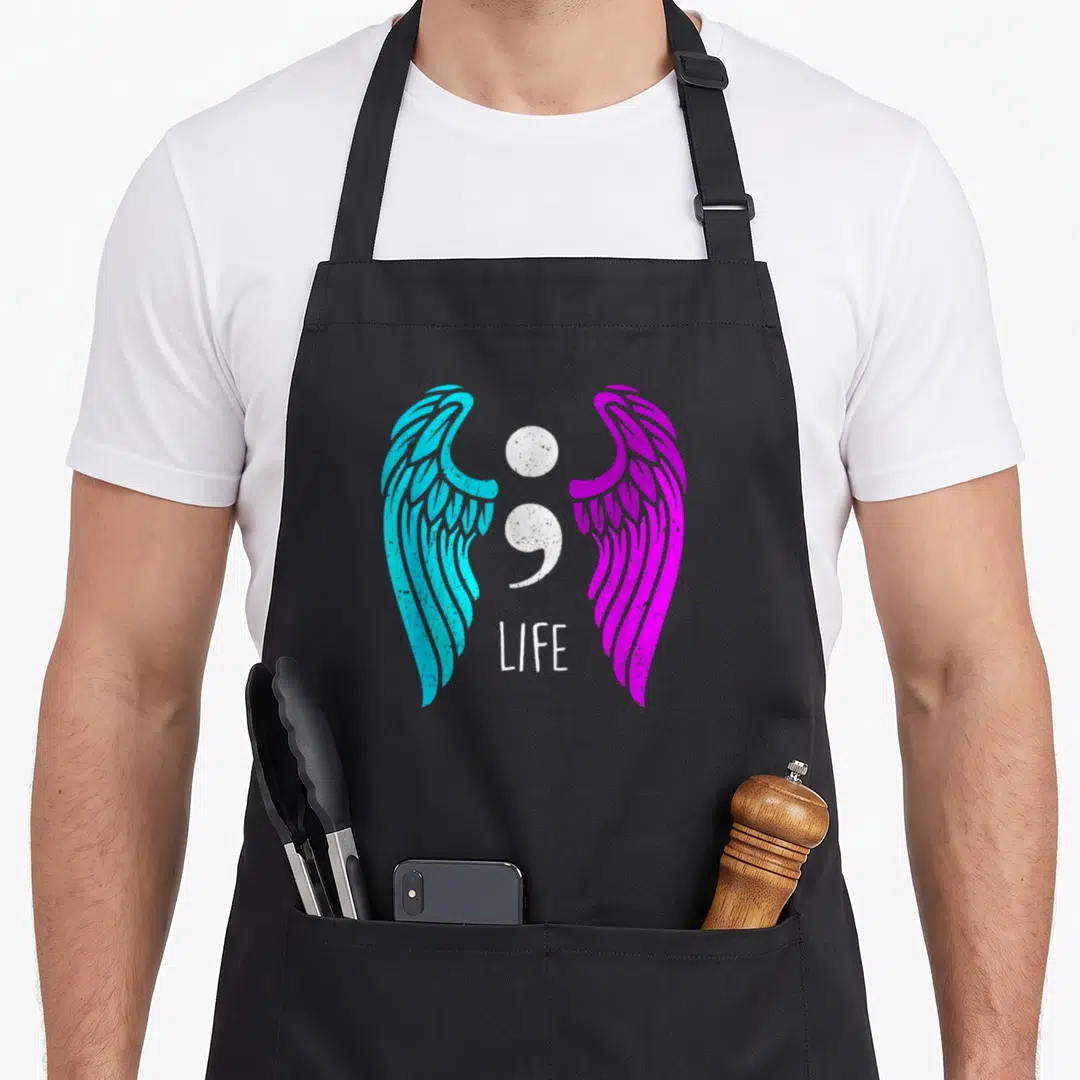 Suicide angels and aprons - White semicolon between blue and magenta wings with LIFE text on black background — shown on a black cotton canvas apron against a white background