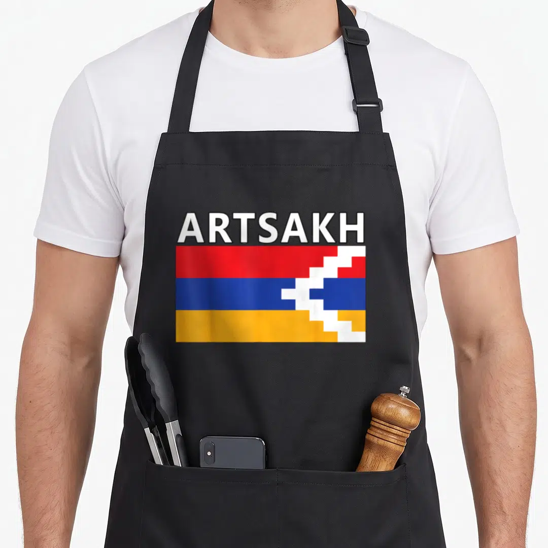 Artsakh armenian apron - ARTSAKH text above red blue orange flag with white pixelated break — shown on a black cotton canvas apron against a white background