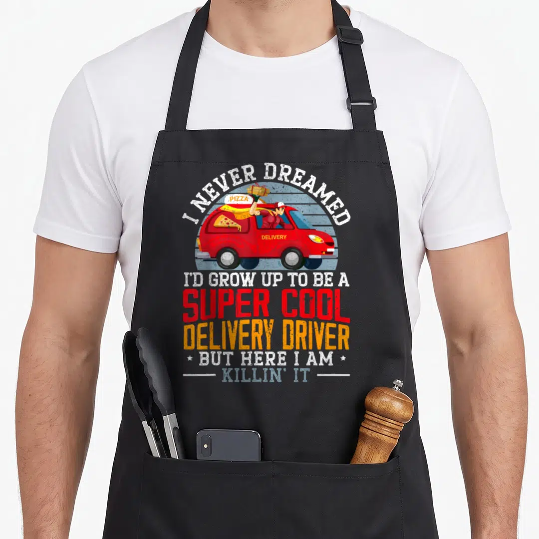 Stemi food aprons - Red delivery van with driver holding pizza and stacked colorful text reading super cool delivery — shown on a black cotton canvas apron against a white background