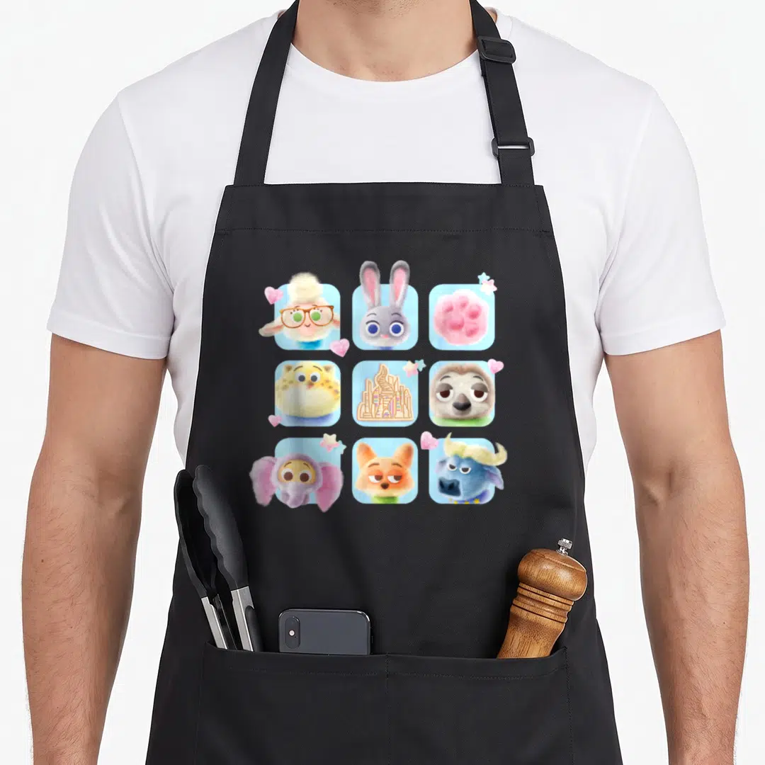 Funny candy friends apron - Nine cartoon animal faces in blue squares with pink hearts and yellow stars — shown on a black cotton canvas apron against a white background