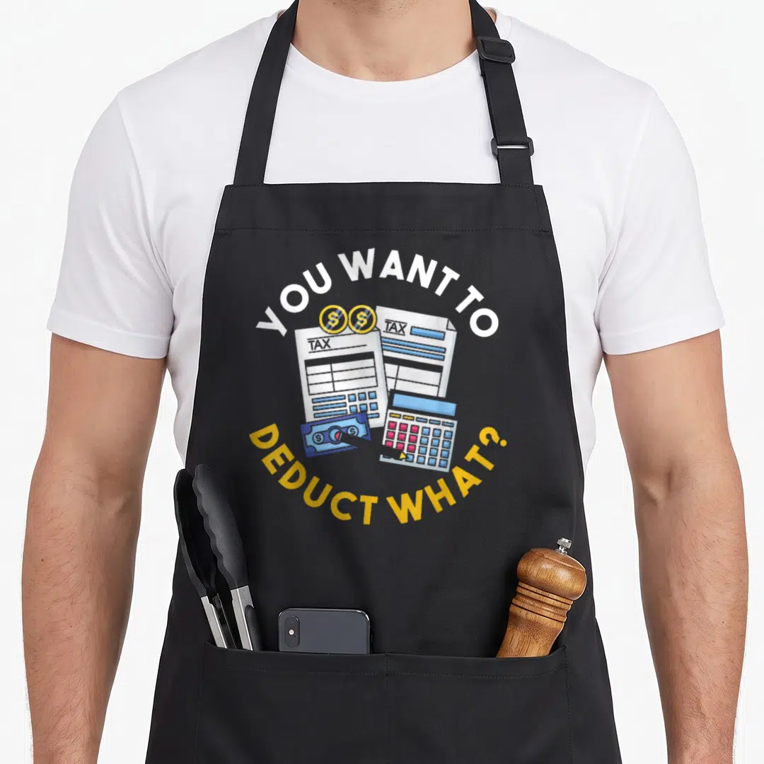 Taxation tax apron - You Want To Deduct What text over tax papers coins and calculator cartoon — shown on a black cotton canvas apron against a white background