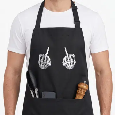 Hand halloween apron - Two white and grey skeleton hands mirroring each other with middle fingers raised in line art — shown on a black cotton canvas apron against a white background