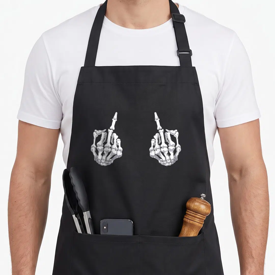 Hand halloween apron - Two white and grey skeleton hands mirroring each other with middle fingers raised in line art — shown on a black cotton canvas apron against a white background