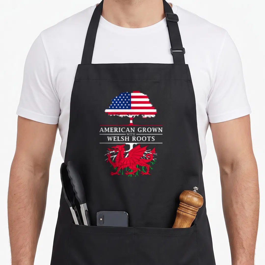 Grown welsh apron - Tree with US flag canopy, red dragon, and American Grown with Welsh Roots text — shown on a black cotton canvas apron against a white background