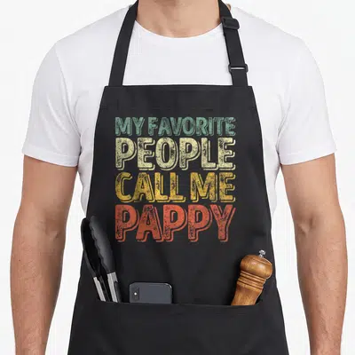Call pappy father day apron - Stacked distressed typography reading My Favorite People Call Me Pappy in green beige — shown on a black cotton canvas apron against a white background