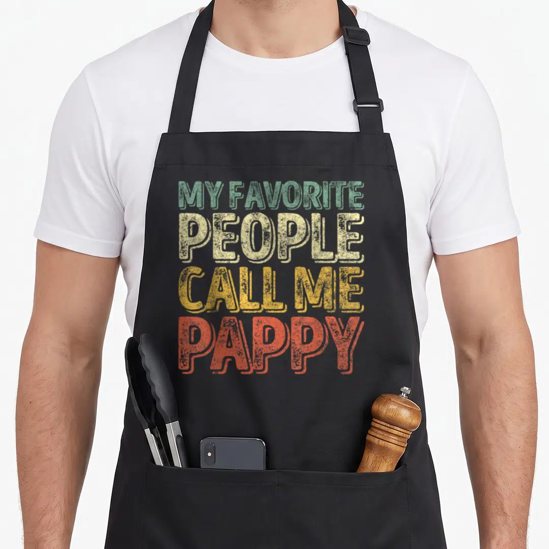 Call pappy father day apron - Stacked distressed typography reading My Favorite People Call Me Pappy in green beige — shown on a black cotton canvas apron against a white background