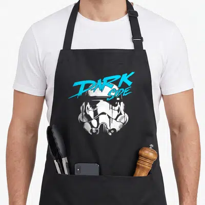 Dark 80s apron - White stormtrooper helmet with cyan DARK SIDE text overlay — shown on a black cotton canvas apron against a white background