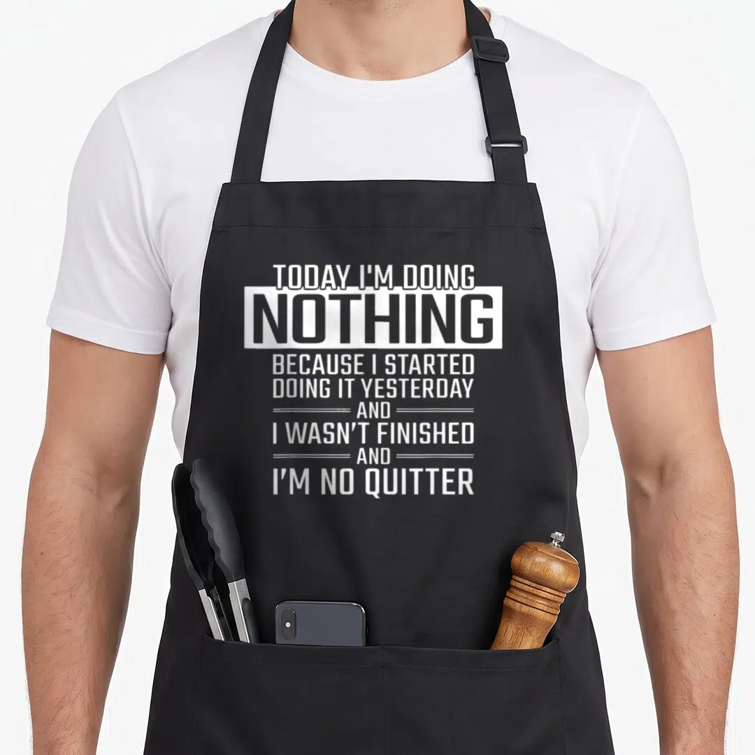 Doing today funny apron - White stacked typography reading Today I'm Doing Nothing Because I Started Yesterday — shown on a black cotton canvas apron against a white background
