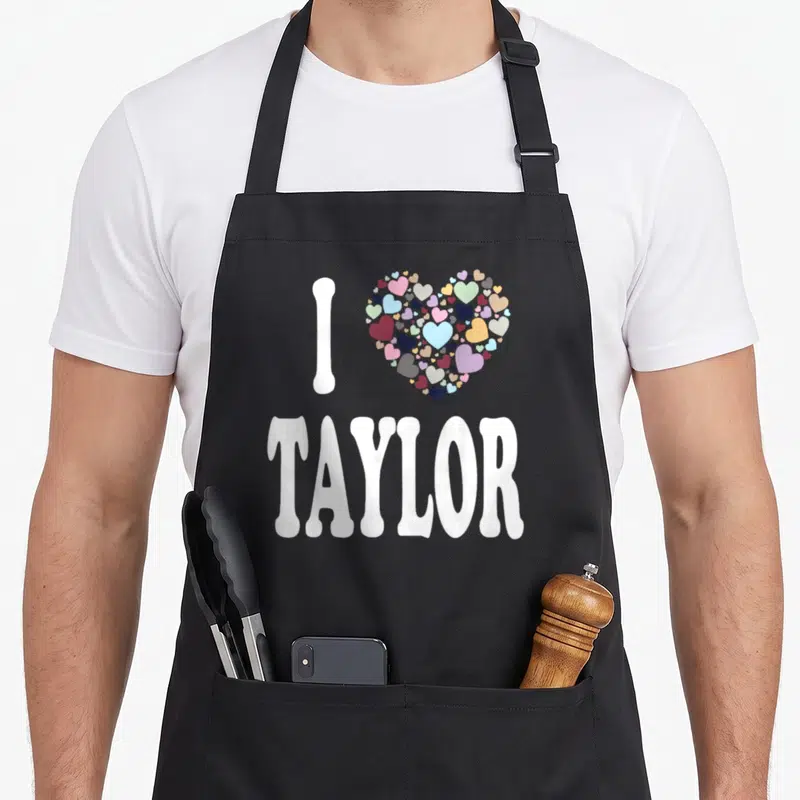 Taylor colorful aprons - I TAYLOR text with large heart made of small pink blue purple yellow white hearts — shown on a black cotton canvas apron against a white background