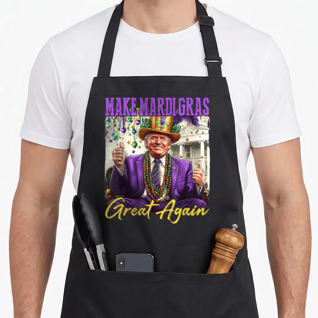 Donald mardi gras aprons - Cartoon Donald Trump in purple suit and beads with Make Mardi Gras Great Again text — shown on a black cotton canvas apron against a white background