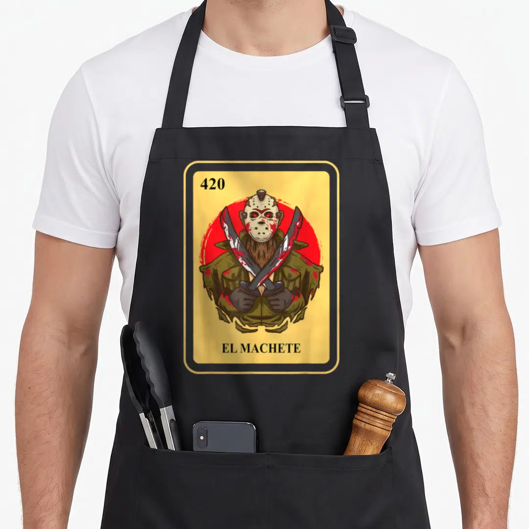 Machete bingo aprons - Cartoon Jason Voorhees holding two crossed machetes inside yellow frame with 420 EL MACHETE text — shown on a black cotton canvas apron against a white background