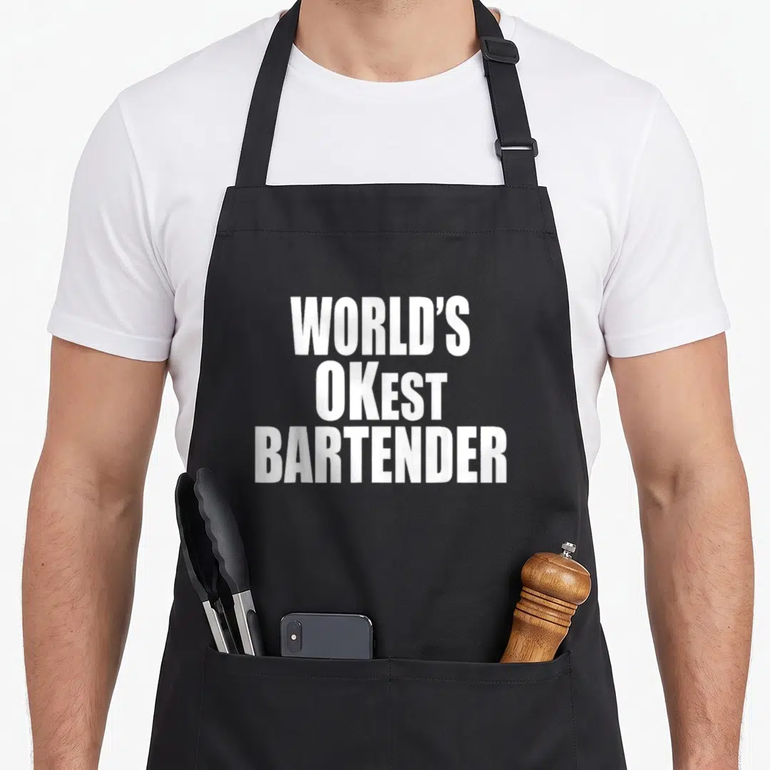 Okest bartender apron - White WORLD'S OKest BARTENDER text stacked vertically on black background — shown on a black cotton canvas apron against a white background