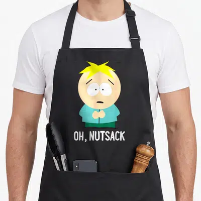 Nutsack butter apron - Butters Stotch cartoon figure above white OH NUTSACK text in blue yellow peach white — shown on a black cotton canvas apron against a white background