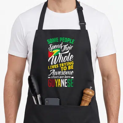 Cute guyanese guyana apron - Stacked text reading born GUYANESE with small flag in green yellow red and white — shown on a black cotton canvas apron against a white background