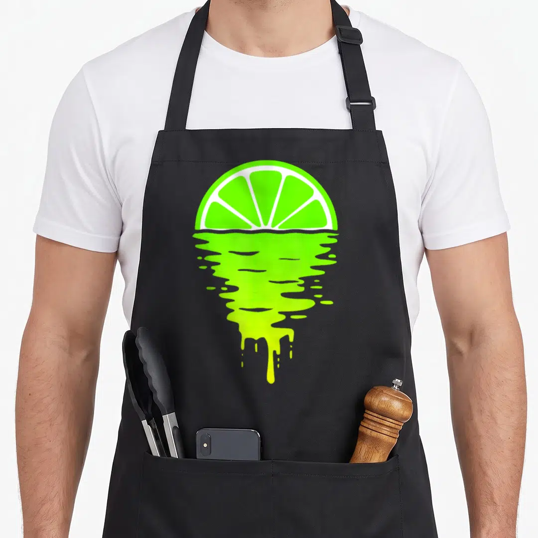 Lime 80s apron - Lime green half-circle slice with dripping liquid reflection in white and green, minimalist style — shown on a black cotton canvas apron against a white background