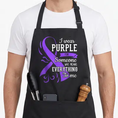Someone insomnia awareness apron - Purple ribbon and white text I wear PURPLE FOR Someone WHO MEANS EVERYTHING To me — shown on a black cotton canvas apron against a white background
