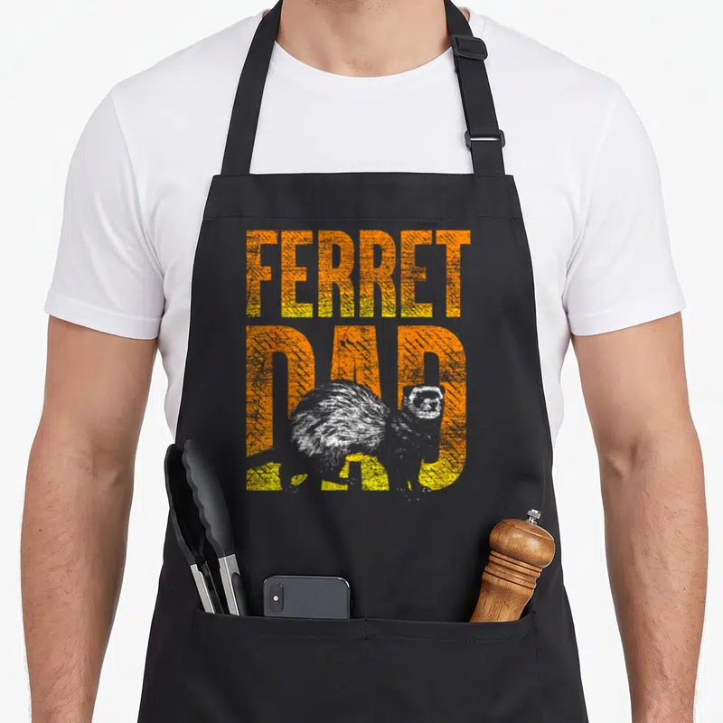 Ferret pet apron - Distressed orange stacked text FERRET DAD with white realistic ferret overlapping bottom letters — shown on a black cotton canvas apron against a white background