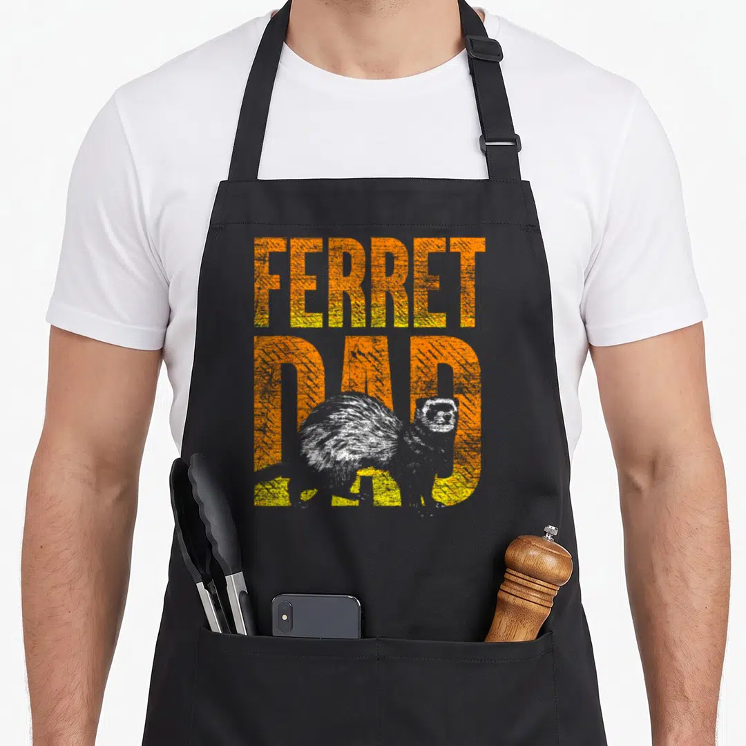 Ferret pet apron - Distressed orange stacked text FERRET DAD with white realistic ferret overlapping bottom letters — shown on a black cotton canvas apron against a white background