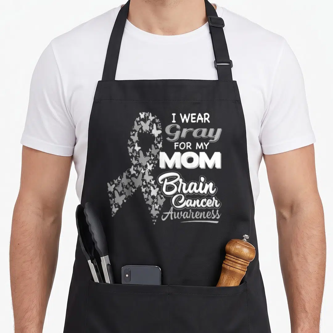 Brain ribbon mom apron - Gray awareness ribbon formed by small butterflies next to stacked white text reading I WEAR — shown on a black cotton canvas apron against a white background